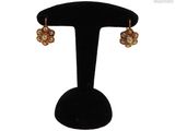 gros plan d'une paire de boucles d'oreilles sur un support noir