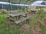 deux tables de pique-nique sous une tente, dans l'herbe