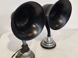 une paire d'enceintes noires posées sur une table blanche, sur fond blanc