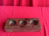 a wooden tray with three cups on it on a red cloth