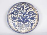 a blue and white plate with a flower design on it