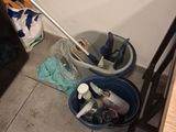a mop and buckets of cleaning supplies on the floor
