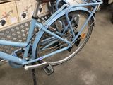 a blue bicycle that is parked next to a pile of boxes