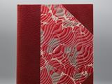 un livre rouge et blanc, avec une couverture rouge ornée d'un motif