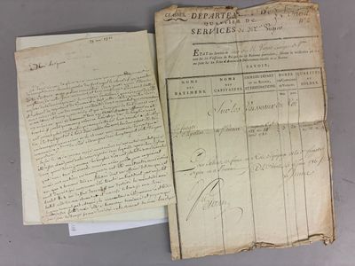 an old document is open on a table next to a piece of paper