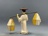 a figurine of a person holding a lantern and a stick