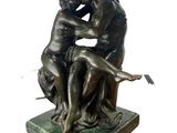 statue of a man and a woman sitting on a base holding a bird