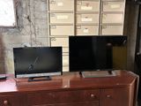 two televisions sitting on top of a dresser in a room