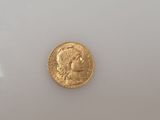 a close up of a gold coin on a white surface