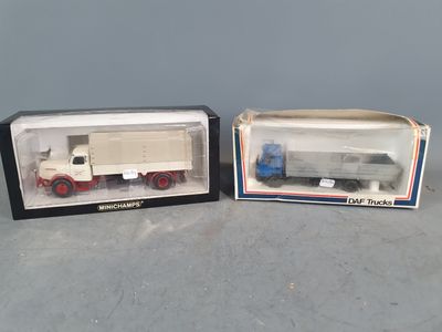 two boxed toy trucks are sitting side by side on a table