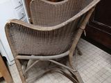 a wicker chair that is sitting in the corner of a room