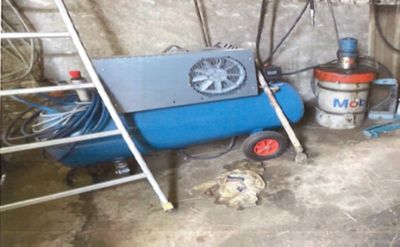 une photo d'une pièce où se trouvent un compresseur bleu et une échelle