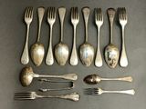 many forks and spoons laid out on a table