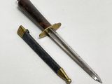 two different types of knives on a white surface