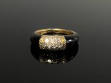 a gold and diamond ring on a black surface