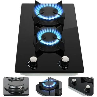trois brûleurs sur une plaque de cuisson noire avec des flammes bleues