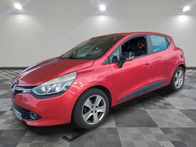 une voiture rouge est garée dans une pièce au sol en damier
