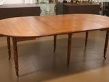 une table en bois dont le plateau a la forme d'une feuille, dans une pièce