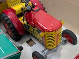 a toy tractor in a box with other toy vehicles