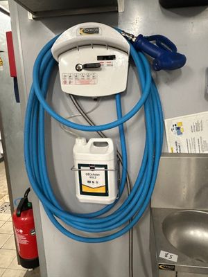 a blue hose attached to the wall of a gas station