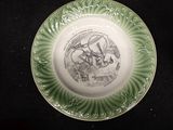 a green plate with a picture of a man riding a horse