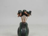 a green vase with three birds on top of it