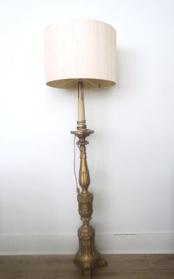 a lamp that is sitting on the floor next to a wall