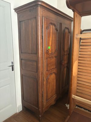 a wooden cabinet in the corner of a room