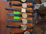 de nombreuses montres posées sur un présentoir en bois