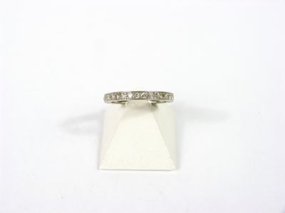 un gros plan d'une bague en diamant posée sur une surface blanche