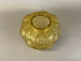 a small glass vase with a gold rim sitting on a white surface