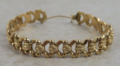 gros plan d'un bracelet en or sur une table