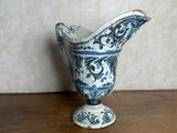 a blue and white vase sitting on a wooden table