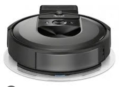 the robot vacuum is on top of a white plate with a remote