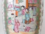 a vase with a painting on it sitting on a table