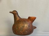 a brown bird shaped vase sitting on a table