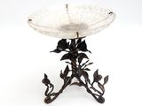 un bol en verre posé sur un socle en métal et orné de fleurs