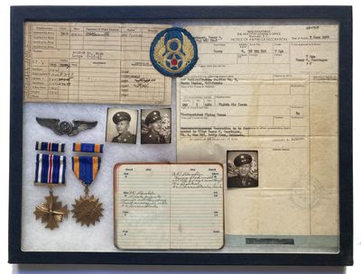 une photo d'une collection de souvenirs militaires présentée dans un cadre vitré