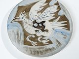 une peinture représentant un oiseau sur une assiette accrochée au mur