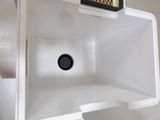 a white refrigerator with a black knob in it