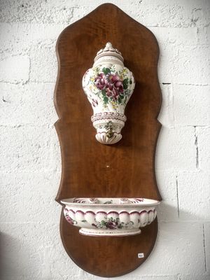 a wall mounted vase on the wall next to a bowl