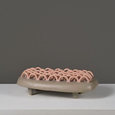 sculpture représentant un hot-dog dans un petit pain, garni de garnitures roses