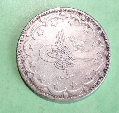 a close up of a silver coin on a green surface