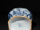 a close up of a blue and white vase on a table