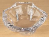 a clear glass ashtray on a wooden table