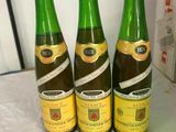 three bottles of wine sitting on top of a table next to a box