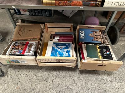boxes of books are stacked on top of a carton on the floor