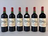 six bouteilles de vin sont alignées sur une table