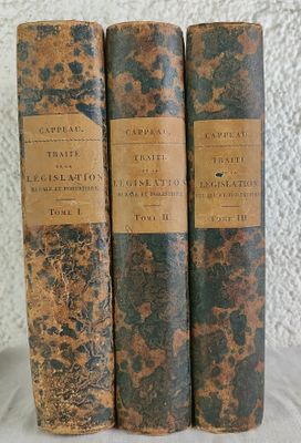 trois vieux livres posés sur une table l'un à côté de l'autre