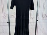 une robe noire suspendue à un cintre dans une pièce